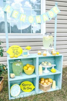 an outdoor lemonade stand is decorated with yellow and blue decorations, such as lemons