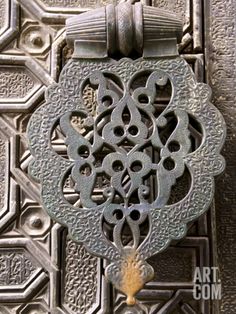 an ornate metal door handle on the side of a building