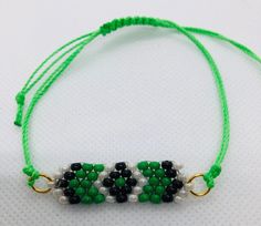 This beadwork project is a green and black beads with green cord friendship design. This is done with size 8/0 Miyuki glass seed beads. It is made adjustable with nylon cord and will fit any size wrist.  If you would like this bracelet done in a different size or colors, let me know and I'll set up a listing for that.  You are purchasing this actual bracelet. Green Braided Bracelets With Sliding Knot And Round Beads, Green Tiny Beads Friendship Bracelets, Green Beaded Bracelets With Adjustable Length, Green Tiny Beads Friendship Bracelet As Gift, Green Friendship Bracelets With Tiny Beads As Gift, Casual Green Jewelry With Black Beads, Handmade Green Braided Bracelets With Round Beads, Green Beaded Friendship Bracelets As Gift, Green Beaded Bracelets With Adjustable Cord For Friendship