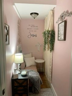 the hallway is painted pink and has a small bench in front of it with a lamp on