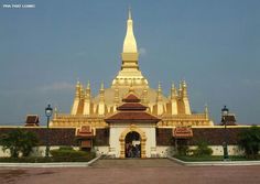 a large golden building with many spires on it's roof and two people standing in the doorway