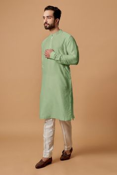 Pista green cotton silk full sleeve kurta with mandarin collared neckline. Paired with pant.
Components: 2
Type Of Work: Plain
Neckline: Mandarin collar
Sleeve Type: Full sleeves
Fabric: Cotton Silk
Color: Green
Other Details: 
Front button detailing
Cuff sleeve hem
Model height: 5ft 10inches, wearing size M
Occasion: Mehendi and Puja - Aza Fashions Pista Green Kurta For Men, Full Sleeve Kurta, Pista Green, Kurta Set For Men, Kurta Set, Full Sleeves, Green Cotton, Mandarin Collar, Cuff Sleeves