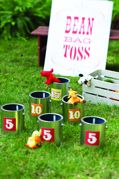 there are many cups with numbers on them in the grass next to a sign that says bean bag toss