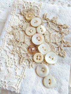 several buttons sitting on top of a lace doily