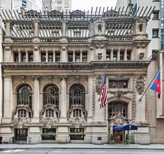 an old building with two flags in front of it