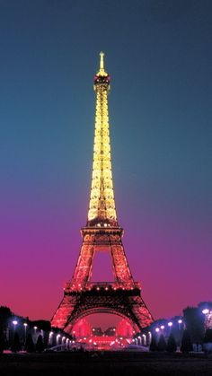 the eiffel tower lit up at night with lights on it's sides