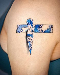 a cross tattoo on the back of a woman's left side ribcage