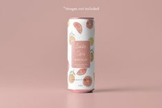 a can of soda with grapefruits and oranges on the side against a pink background