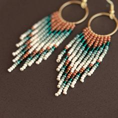 Embrace the spirit of bohemian flair with these captivating fringe beaded hoop earrings. Featuring a stunning interplay of turquoise and burnt orange beads, they cascade playfully from high-quality, lightweight hoops. Each meticulously handwoven bead adds to the unique and vibrant design, ensuring these earrings become cherished conversation starters. More than just an accessory, these earrings are testaments to artisan skill.  The intricate beadwork and high-quality materials elevate them beyon Bohemian Fringe Dangle Hoop Earrings, Bohemian Dangle Fringe Hoop Earrings, Bohemian Dangle Jewelry With Beaded Fringe, Bohemian Turquoise Tassel Earrings With Beaded Fringe, Bohemian Hoop Earrings With Tiny Beads, Burnt Orange Accents, Hoop Earrings Diy, Beaded Designs, Native Beading