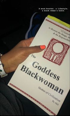 a person holding a book in their left hand and pointing at it with the title'the goddess blackwoman mother of civilization '