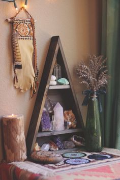 a shelf filled with rocks and other items next to a wall mounted vase on the wall