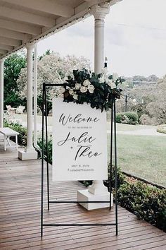 a welcome sign with flowers on the front porch