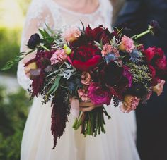 a bride holding a bouquet of red and pink flowers in her hand with the caption happywedd com