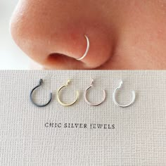 three pairs of silver hoop earrings sitting on top of a white piece of paper with the word