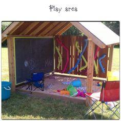 an outdoor play area with chairs and chalkboard