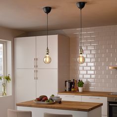 a kitchen with white cabinets and wooden counter tops