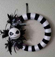 a black and white wreath with a jack skellingy face hanging on the wall