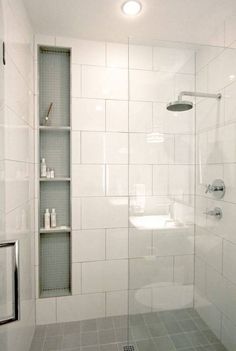 a bathroom with a shower, toilet and shelves on the wall next to each other