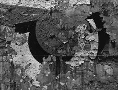 an abstract black and white photograph of the letter c on a wall with peeling paint