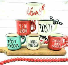 four coffee mugs are sitting on top of a wooden board with red beads around them