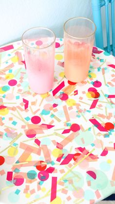 two glasses sitting on top of a table covered in confetti