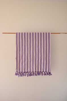 a purple and white striped towel hanging on a clothes line