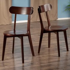 two wooden chairs sitting on top of a hard wood floor