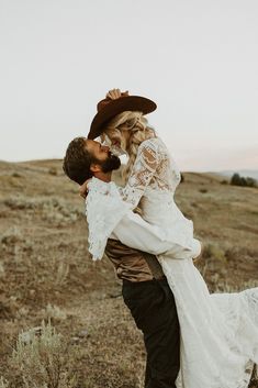 a bride and groom kissing in an open field