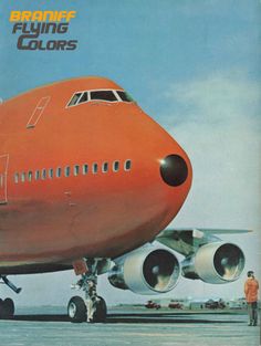 an orange airplane sitting on top of an airport tarmac