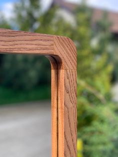 a close up of a wooden frame with trees in the background