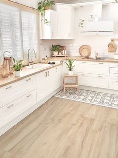 a kitchen with white cabinets and wooden floors