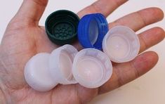 the hand is holding several small plastic containers