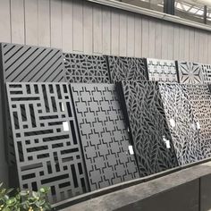 a row of black and white wall panels next to a planter filled with flowers