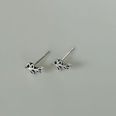 A PAIR of tiny sterling silver leaves on a stem sear studs. Size: 5 x 7 mm These earrings are made of 925 hypoallergenic sterling silver. All my pieces are sent in a gift box. I can include a personal message from you if needed. You are welcome to contact me at... bhavnakwintra1956@gmail.com More hoops: https://www.etsy.com/your/shops/TheSilverGame/tools/listings/section:26305414 More earrings: https://www.etsy.com/your/shops/TheSilverGame/tools/listings/section:26308789 Ear climbers: https://ww Silver Leaf Minimalist Earrings, Minimalist Silver Leaf Earrings, Silver Leaf-shaped Minimalist Earrings, Silver Leaves, Tiny Star, Ear Climbers, Ear Stud, Cartilage Earrings, Feather Earrings