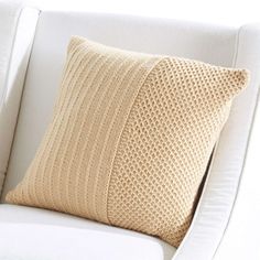 a white chair with a beige pillow on it's back and armrests