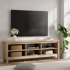 a flat screen tv mounted to the side of a wooden entertainment center in a living room