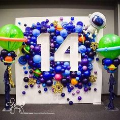 balloons and streamers are arranged around the number fourteen sign