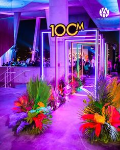 the entrance to an event with flowers and neon lights