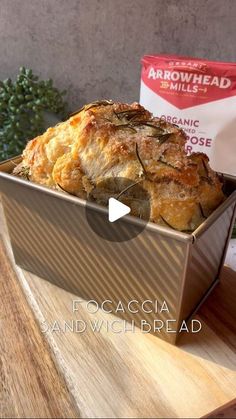 a box filled with food sitting on top of a wooden table next to a bag of bread