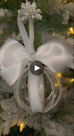 a christmas ornament hanging from the top of a tree with a bow on it