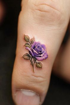 a small purple rose tattoo on the foot