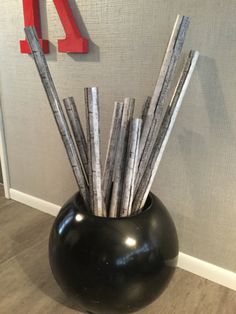 a black vase with sticks sticking out of it