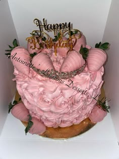 a birthday cake with pink frosting and roses on top in a white cardboard box