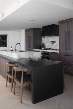 a kitchen with an island counter and chairs