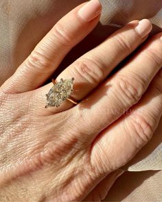 a woman's hand with a diamond ring on it