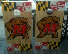 two cornhole game boards with the letter m on them