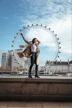 a woman standing in front of a ferris wheel