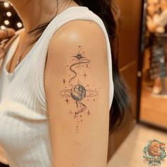 a woman with a tattoo on her arm that has an image of the earth and stars