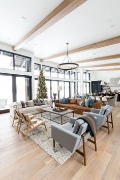 a living room with couches, chairs and a christmas tree in the middle of it