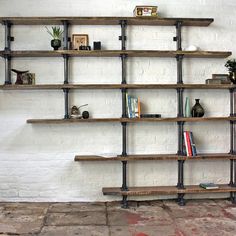 the shelves are made from wood and have metal pipe rods on them, along with bookshelves